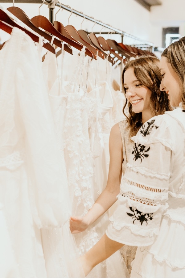 Photo of the smiling models looking at the bridal gowns